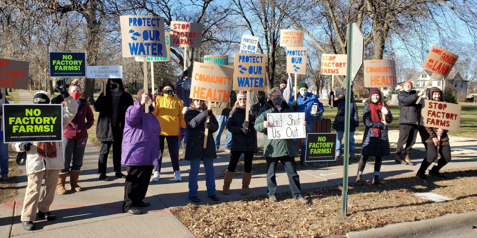 community holding signs against factory farms