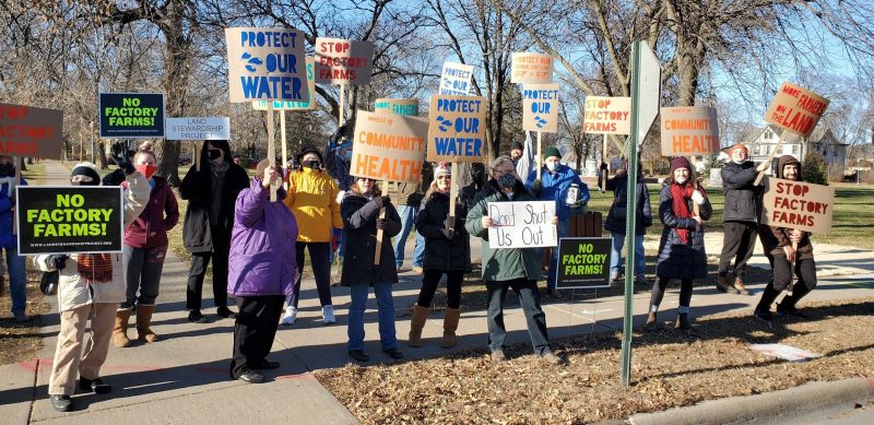 community holding signs against factory farms